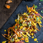 Carrot almond salad - ribbons of rainbow carrots, doused in creamy, turmeric coconut dressing, topped with toasted almonds and fresh cialntro - an explosion of exotic flavors that will surely tantalize your taste buds! | www.viktoriastable.com