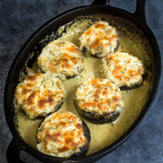 Stuffed mushrooms with prosciutto and ricotta, baked in super delicious, creamy pesto sauce! | www.viktoriastable.com