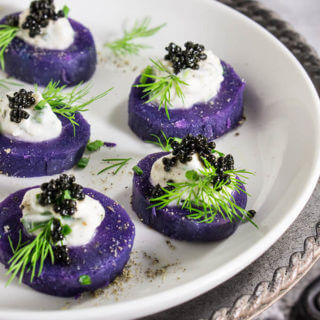 Purple potato bites with horseradish creme fraiche and caviar - bold colors and big flavors packed into a small, delicious morsel - the perfect starter for your holiday dinner or a cocktail party. | www.viktoriastable.com