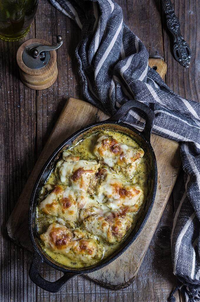 Stuffed chicken roll ups - delicious and easy to make, stuffed with pesto, prosciutto, sun-dried tomatoes and goat cheese, then smothered in creamy garlicky sauce, topped with mozzarella, and baked to perfection! | www.viktoriastable.com