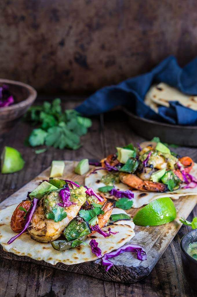 Grilled shrimp tacos with tomatillo salsa and homemade tortillas - bursting with flavor, juicy shrimp, grilled ppoblano peppers and tomatoes, topped with freshly made salsa verde, and served over soft homemade flour tortillas. | www.viktoriastable.com