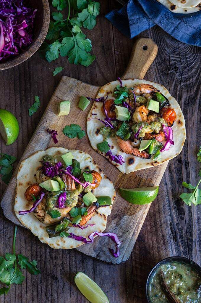 Grilled shrimp tacos with tomatillo salsa and homemade tortillas - bursting with flavor, juicy shrimp, grilled ppoblano peppers and tomatoes, topped with freshly made salsa verde, and served over soft homemade flour tortillas. | www.viktoriastable.com